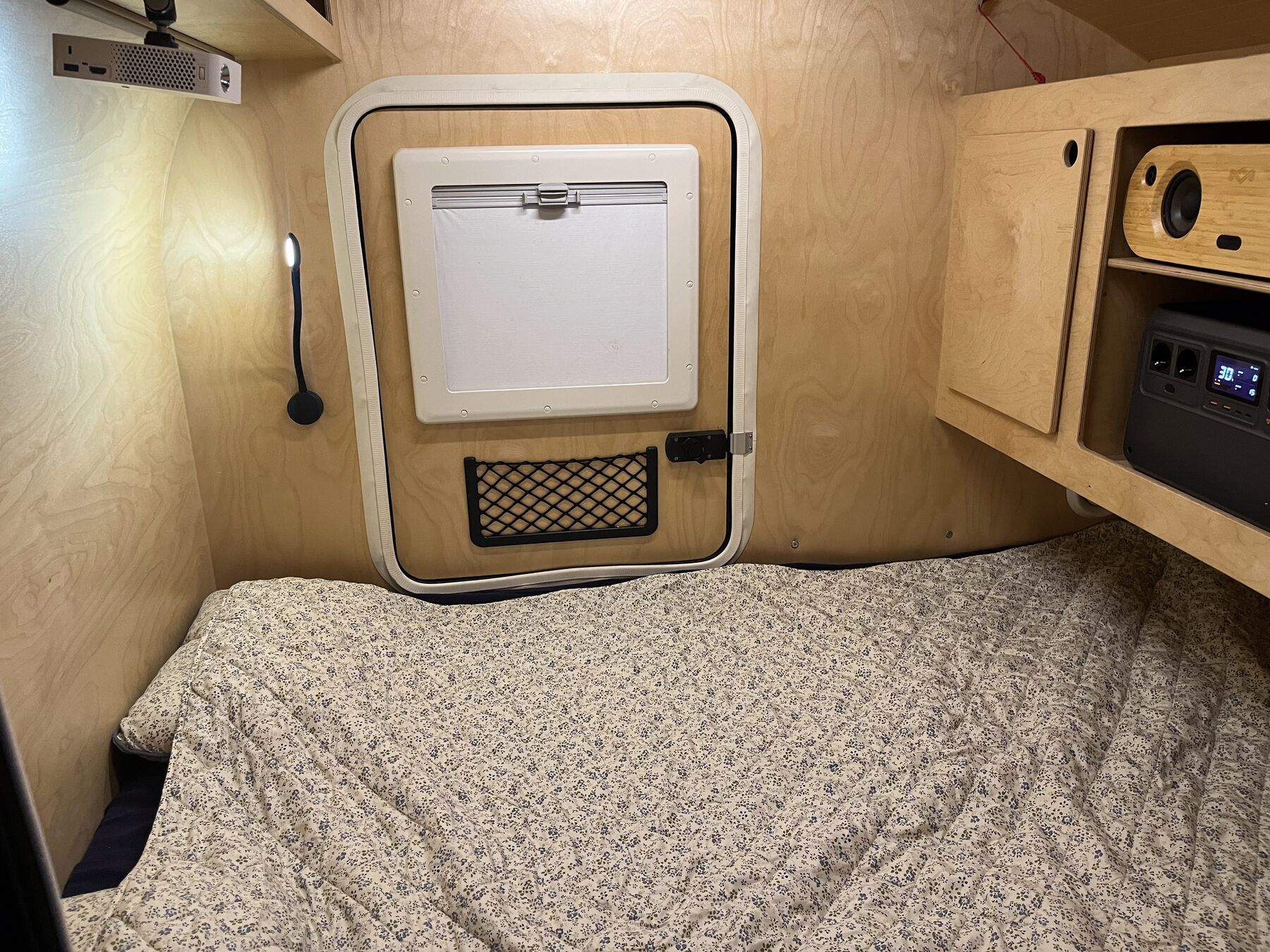 Het opgemaakte bed in de Kulba Rebel, met dakluik, leeslamp en bergruimte